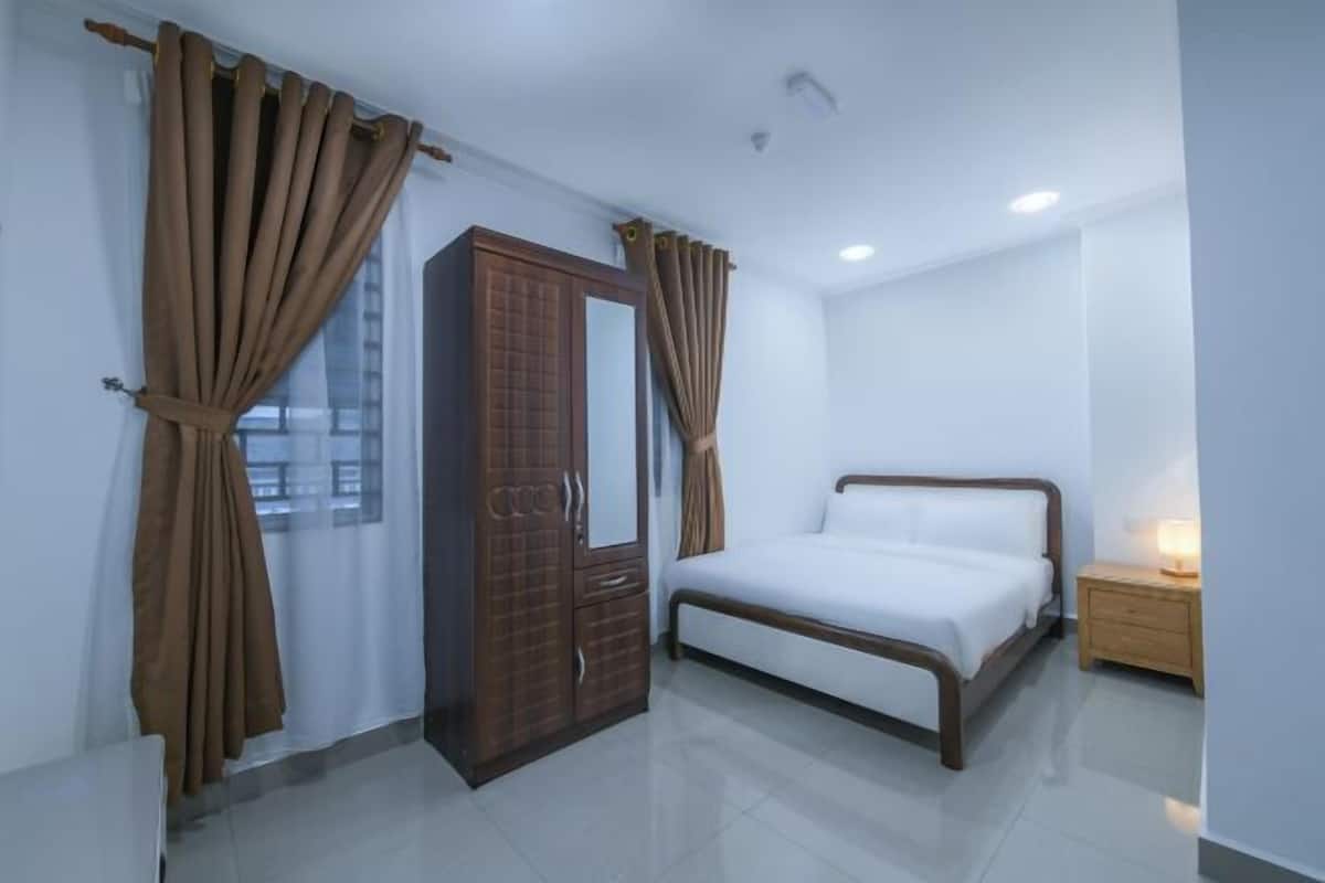 Une chambre Ă coucher avec un lit, une armoire et une table de chevet.