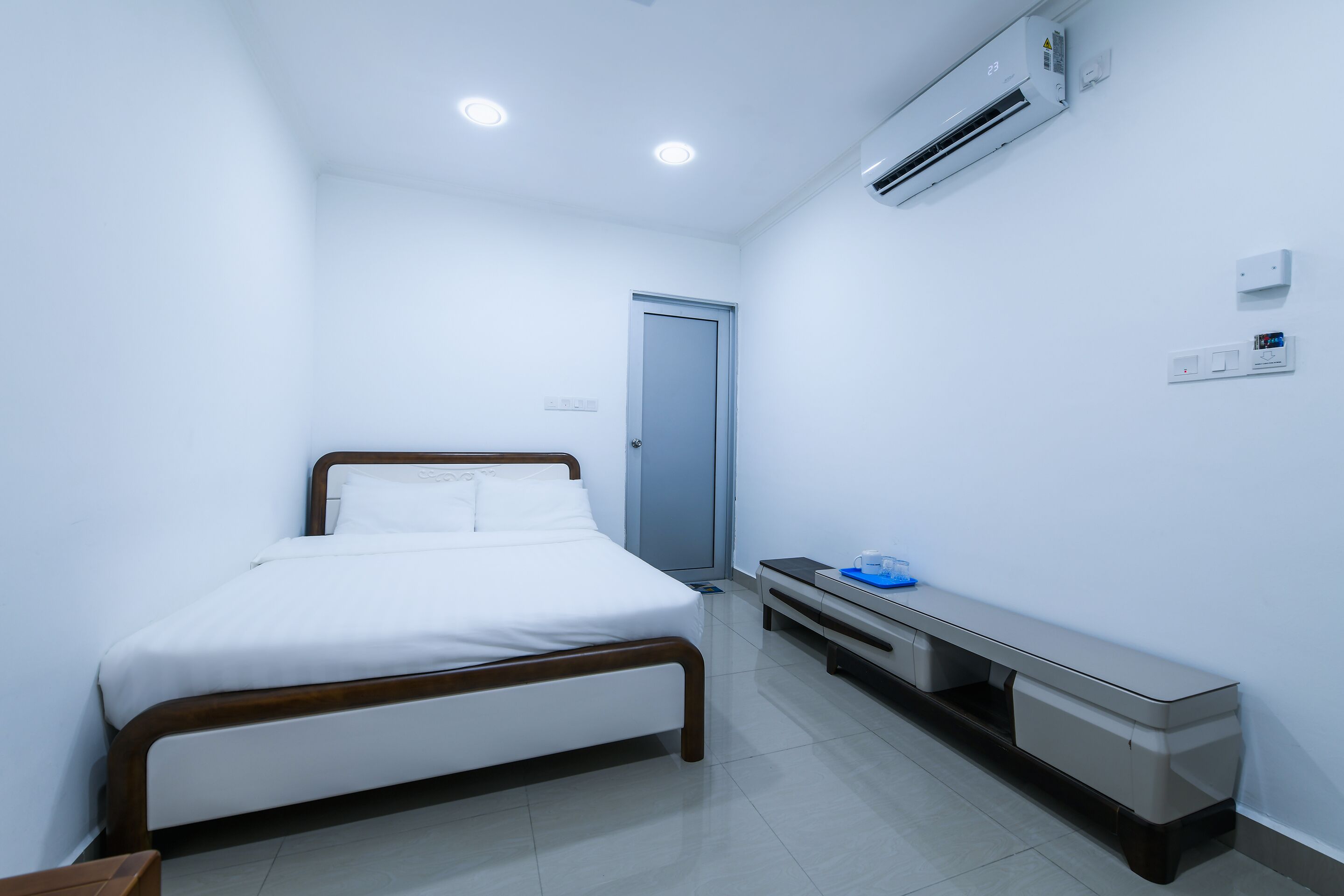 Une chambre d’hôtel équipée d’un lit, d’une table de chevet et d’un système de climatisation intégré.