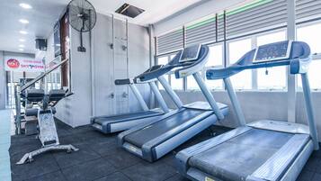 A gym with treadmills, a fan, and a sign for 'Sky Gym'.