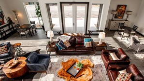 Eine großzügige Lobby mit Ledersofas, einem Couchtisch und einem Essbereich.