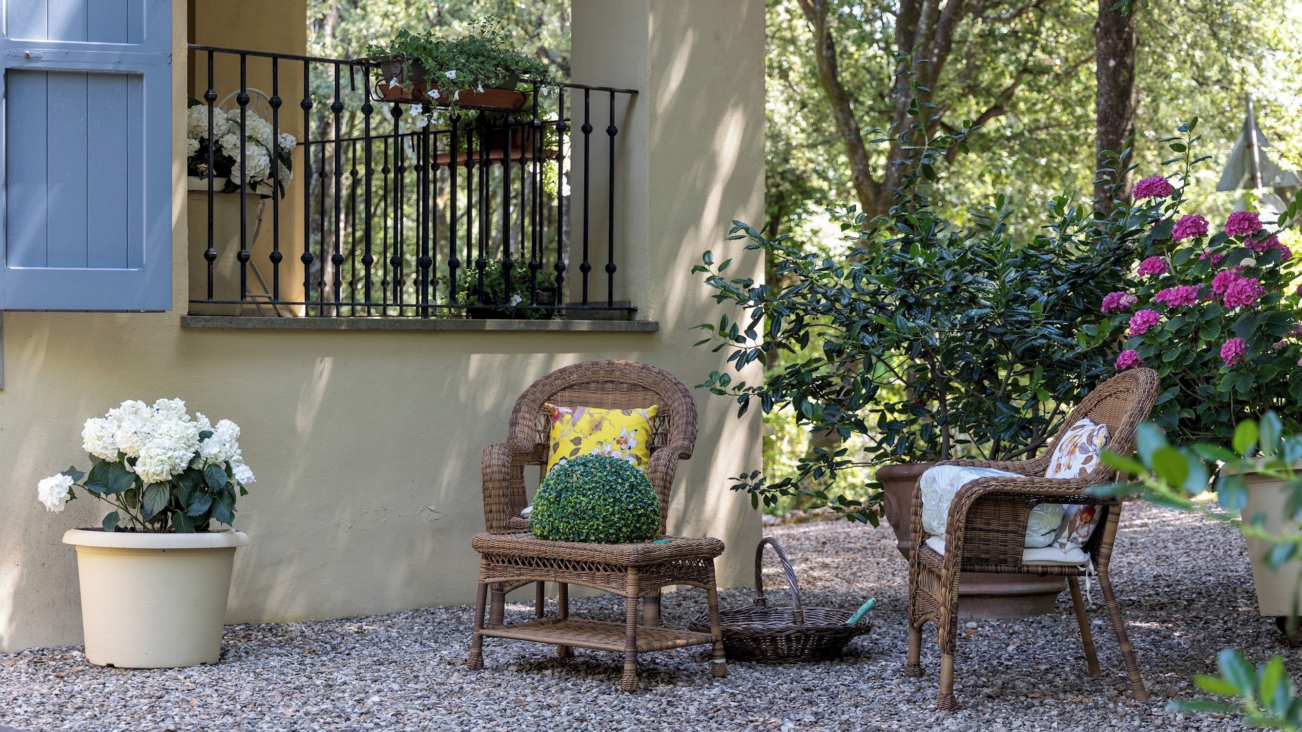 Un balcon agrémenté de plantes en pot et d’une chaise en osier.