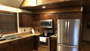 A kitchen with wooden cabinets, stainless steel appliances, and a granite countertop.