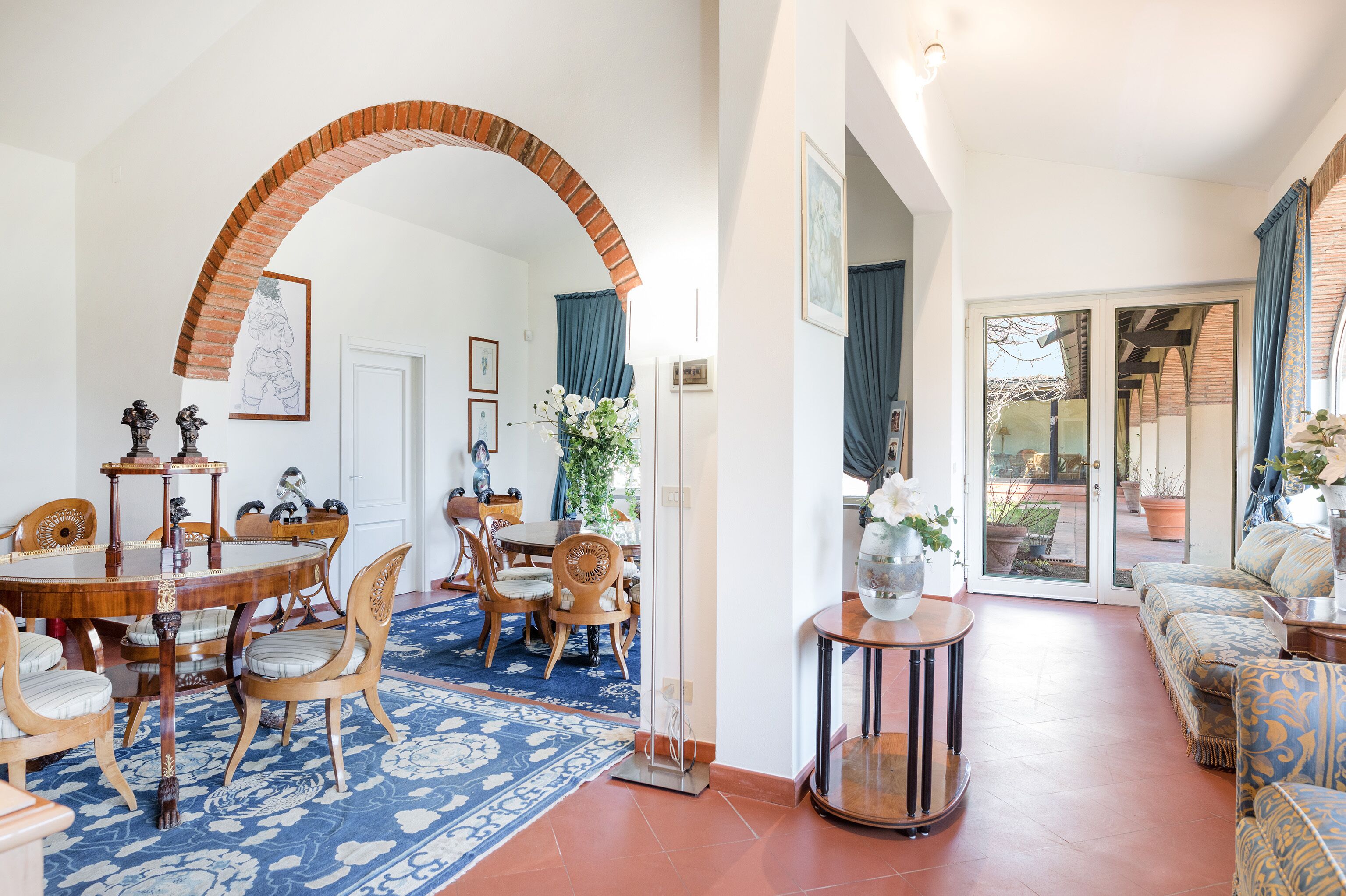 A spacious living area with a dining table, chairs, a sofa, and a coffee table.