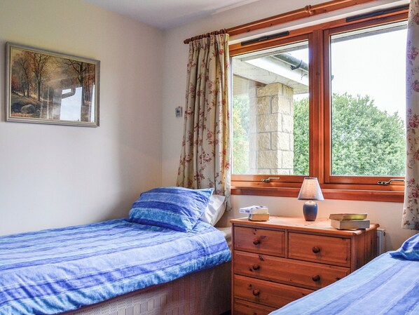A bedroom with a single bed, a wooden dresser, a window with curtains, and a painting on the wall. - 4 bedroom accommodation in Spittalfield, nr Dunkeld (Spittalfield, nr Dunkeld)