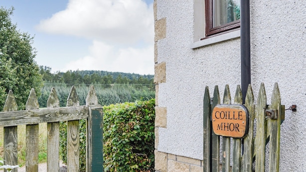 A wooden gate with a sign reading "COILLE MHOR" in front of a stone building with a window. - 4 bedroom accommodation in Spittalfield, nr Dunkeld (Spittalfield, nr Dunkeld)