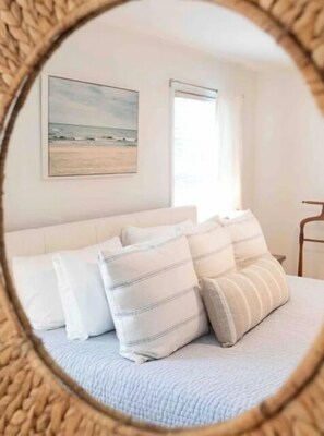 A bedroom with a bed, pillows, a window, and a painting on the wall. - Entire townhouse- 10mins to beaches or downtown (Mount Pleasant)