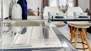 A modern kitchen with a black countertop, stainless steel sink, and a ceiling fan. - Villa with private pool, close to the beach (El Carmoli)