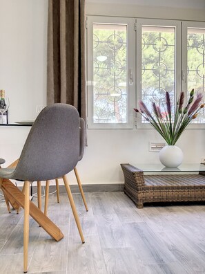 A modern living room with a grey upholstered chair, a wicker sofa, a glass coffee table, and a vase with pampas grass. - Villa with private pool, close to the beach (El Carmoli)