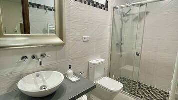 Een bad/douchecombinatie, een haardroger, handdoeken, zeep