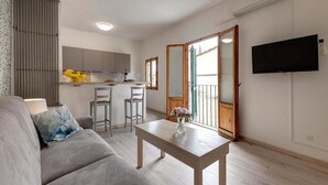 A modern living room with a sofa, a coffee table, and a kitchen area in the background. - Lezioso "VIP", 2 bedrooms in the heart of Florence (Firenze)