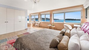 A modern bedroom with a large bed, a desk, and a view of the sea. - Adriatic Beach House (Vrbica)