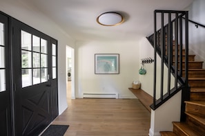 Staircase leads to a cozy space with a framed picture and a small basket.