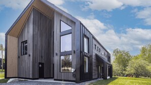 Un bâtiment moderne à deux étages, doté de grandes fenêtres et d’un toit en pente.