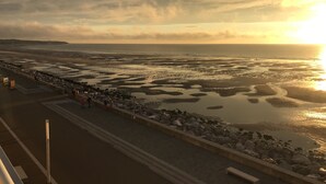 Une promenade en bord de mer offrant une vue sur la mer et un magnifique coucher de soleil.