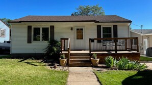 A single-story house with a front porch, a small front yard, and a mailbox.