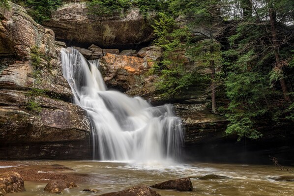 A waterfall cascading over rocks in a forested area.