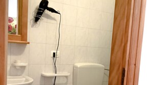 Ein Badezimmer mit Waschbecken, Bidet, Toilette und einem an der Wand montierten Fön.