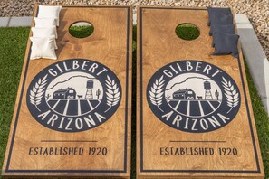 Two wooden dartboards with the Gilbert Arizona logo, established in 1920, and a small green patch of grass between them. - Family Hideaway w/ Heated Pool & Ping Pong (Gilbert)