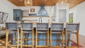 A dining area with a wooden table and four chairs with woven seats.