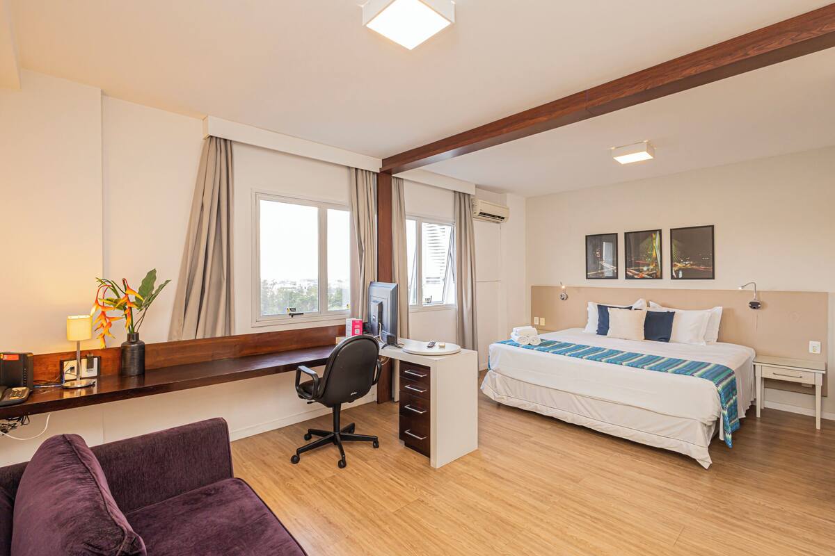 Une chambre d’hôtel comprenant un lit, un bureau, une chaise et un petit coin salon.