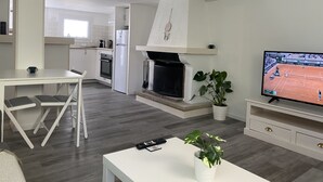A modern living room with a TV, a dining area, and a kitchen. - Cosy apartment in a 2** residence (Martigues)