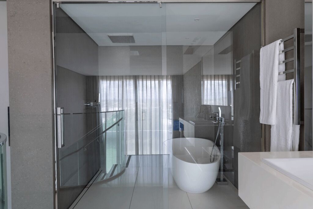 A modern bathroom with a glass shower enclosure, a freestanding bathtub, and a glass-enclosed walk-in shower.
