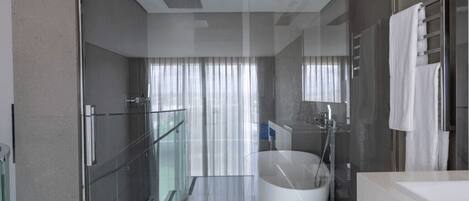 A modern bathroom with a glass shower enclosure, a freestanding bathtub, and a glass-enclosed walk-in shower.