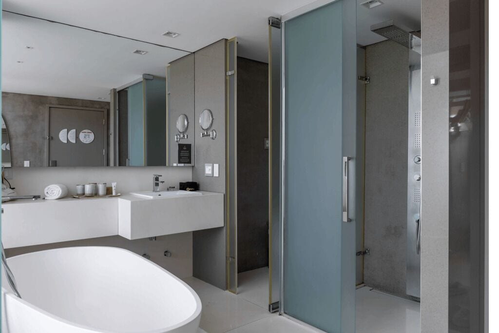 Une salle de bain moderne avec une baignoire sur pieds, un grand miroir et une douche à l’italienne.