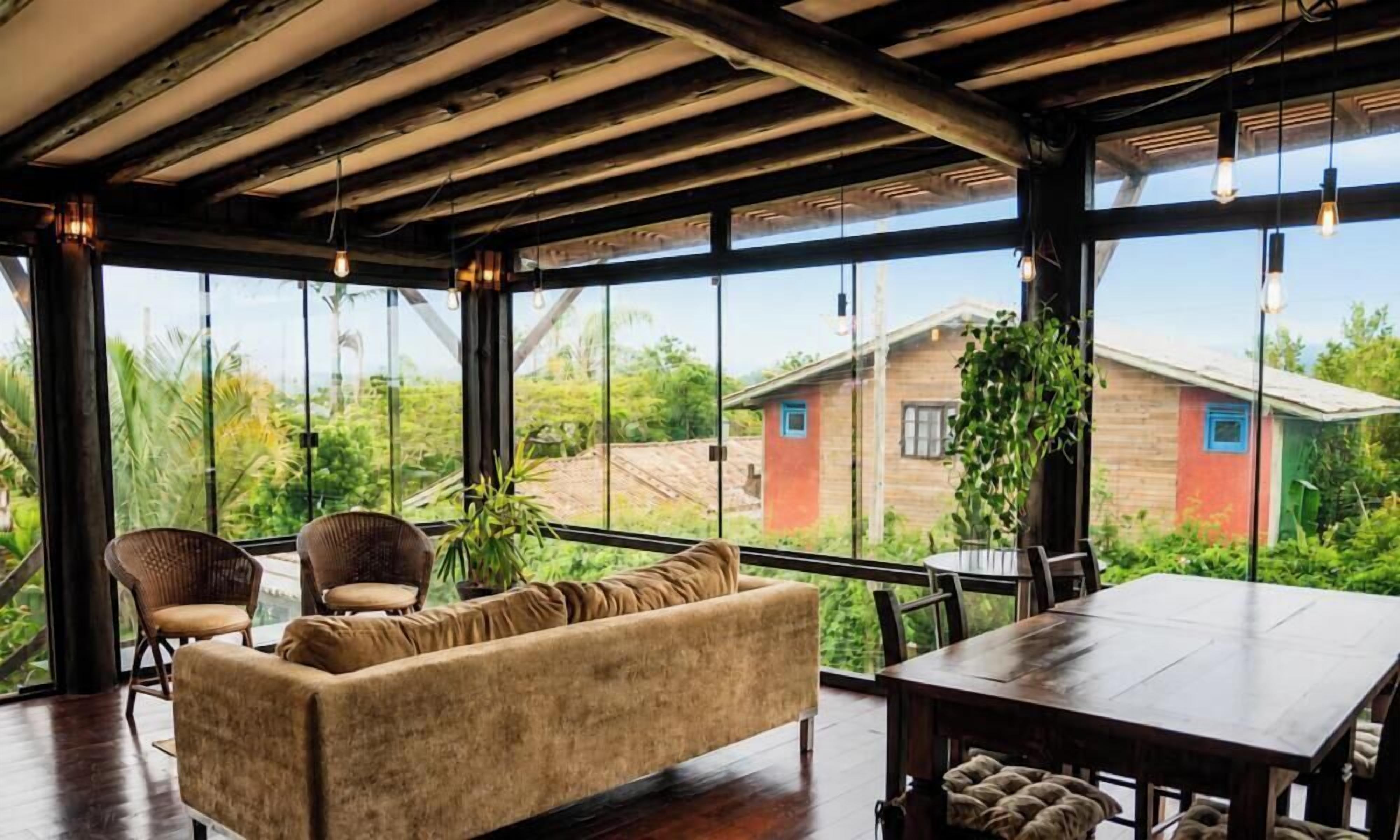 Una habitación amplia con un gran ventanal, un sofá, una mesa de comedor y sillas.