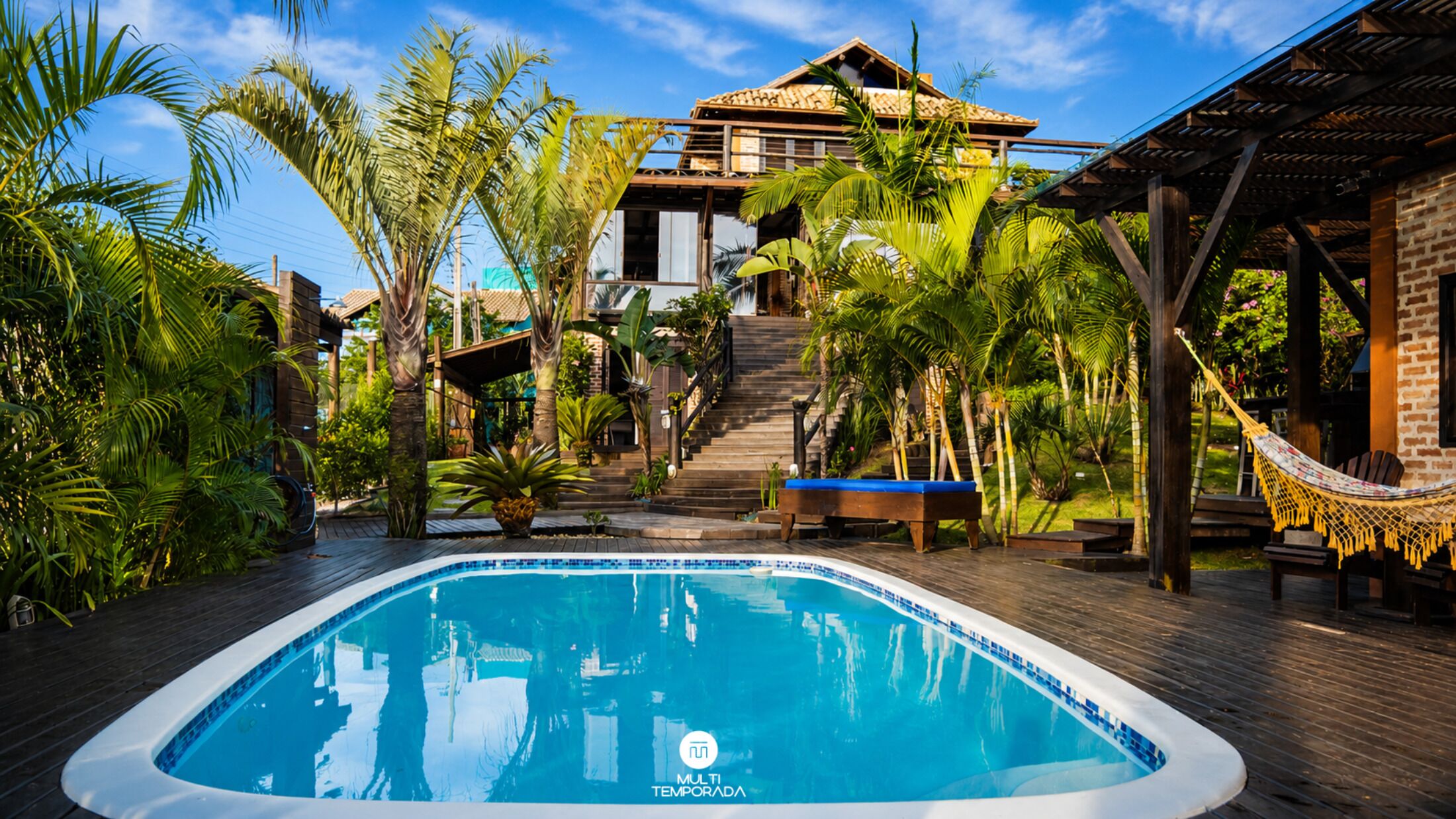 Una piscina al aire libre, sombrillas, sillones reclinables de piscina