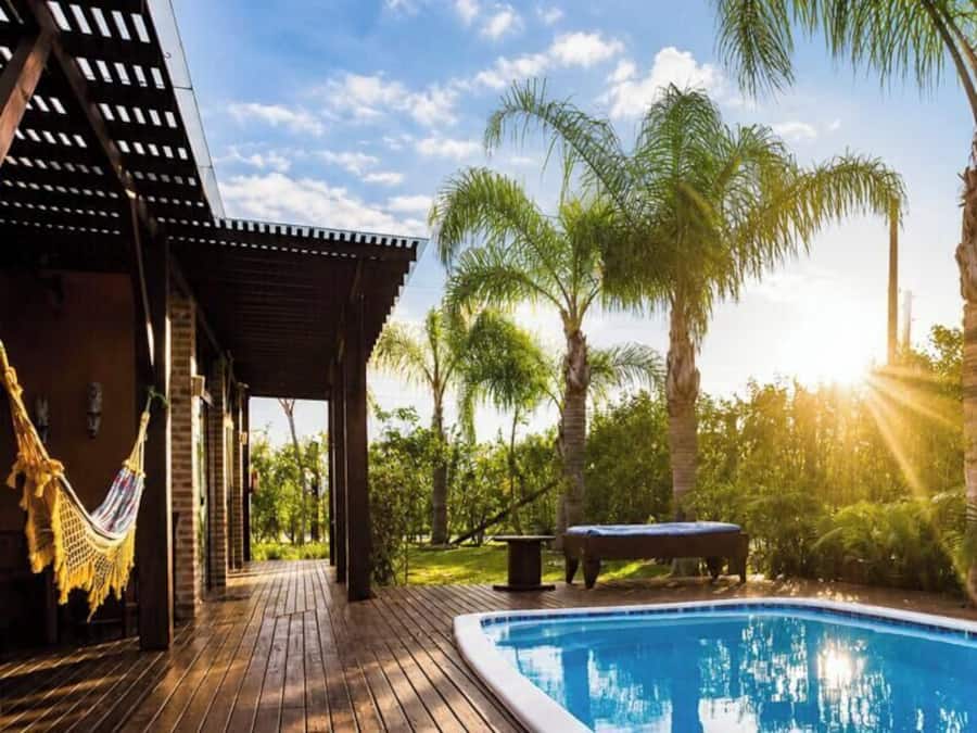Una piscina al aire libre, sombrillas, tumbonas