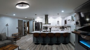 A modern kitchen with a central island, bar stools, and a built-in TV. - The Reserve NEW condo, 2 blocks to Walla Walla Main Street (Walla Walla)