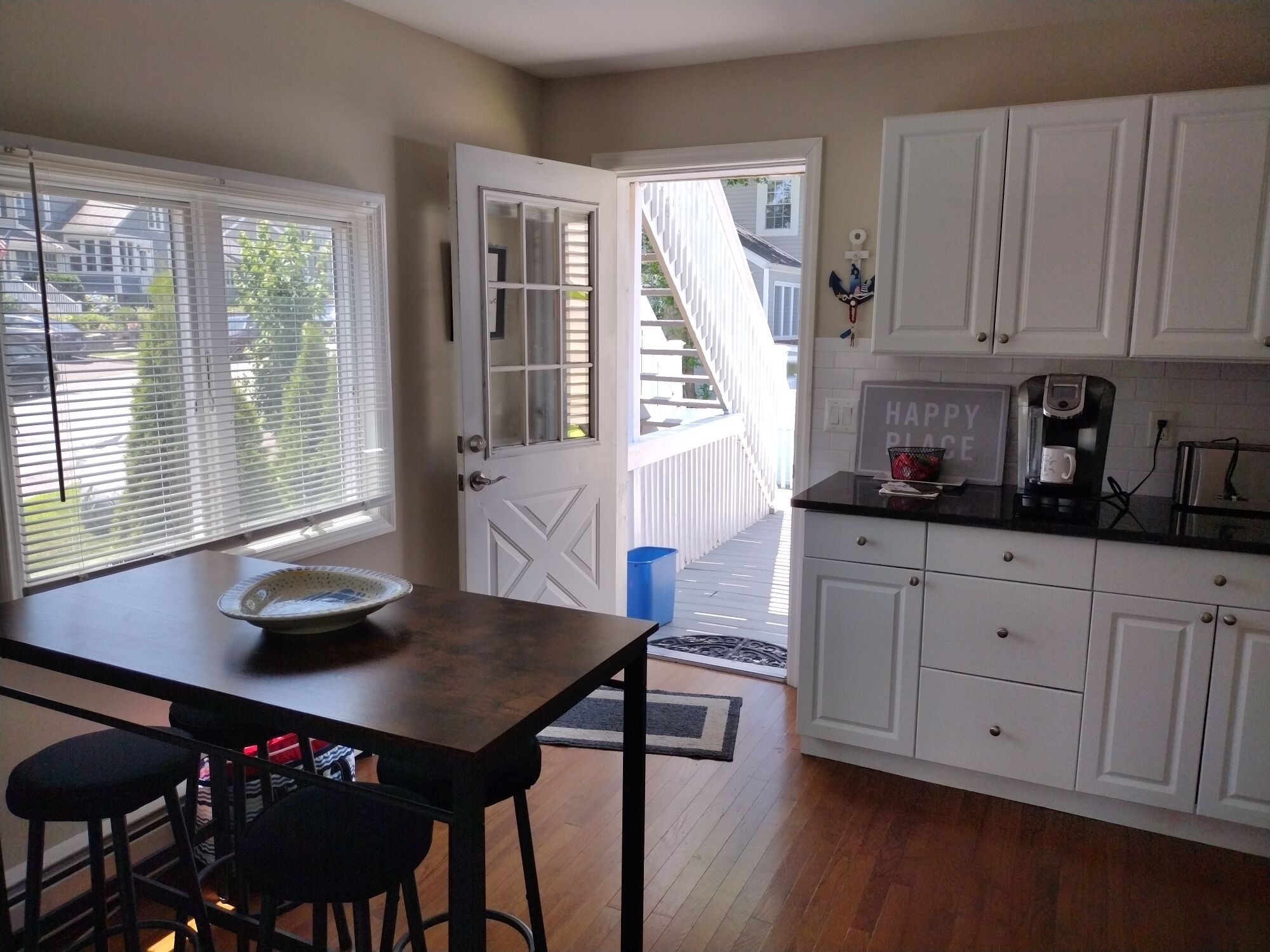 A kitchen with white cabinets, a coffee maker, and a bowl on the counter.