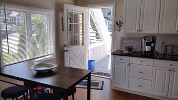 A kitchen with white cabinets, a coffee maker, and a bowl on the counter.