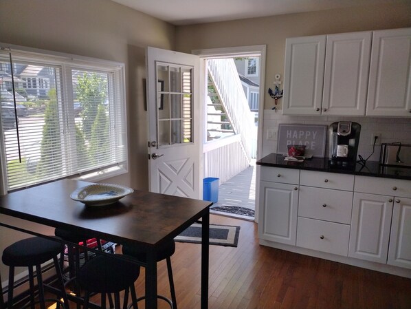 A kitchen with white cabinets, a coffee maker, and a bowl on the counter.