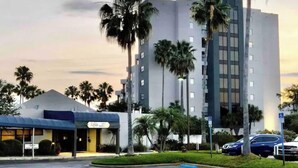 A hotel with a modern design, featuring a large building with multiple floors and a parking lot in front. - Universal/Pool view +FREE parking. Newly renovated 2bdrm/2bth (Orlando)