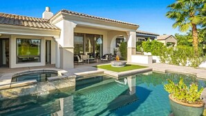 Una casa moderna con piscina, mobiliario exterior y un jardín bien cuidado.