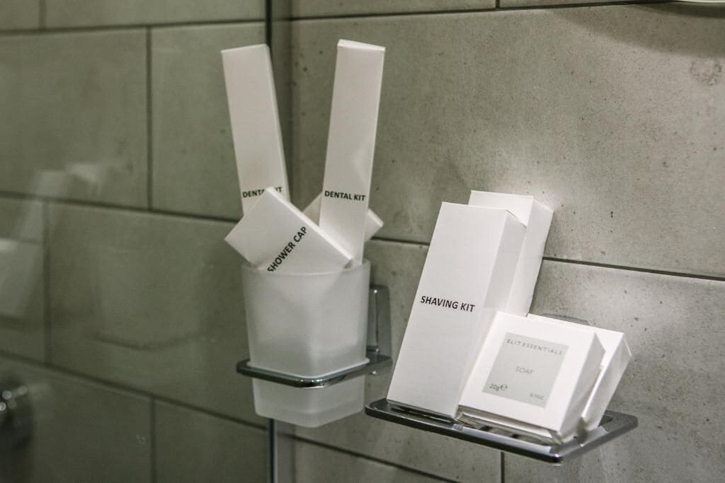 Baño con dispensador de gorro de ducha y de kit de afeitado.