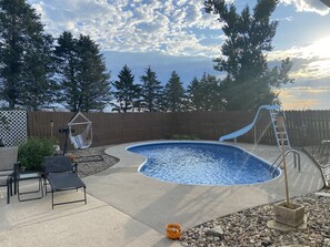 An outdoor swimming pool with a slide, surrounded by a wooden fence and trees. - Slice of Heaven - Private pool - 4 Bedroom (Colo)