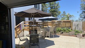 An outdoor patio with a table and chairs, a grill, and a wooden fence. - Slice of Heaven - Private pool - 4 Bedroom (Colo)