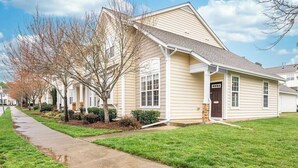A single-story residential house with a front porch, a driveway, and a lawn.