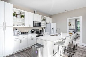 Fridge, dishwasher, coffee/tea maker, cookware/dishes/utensils