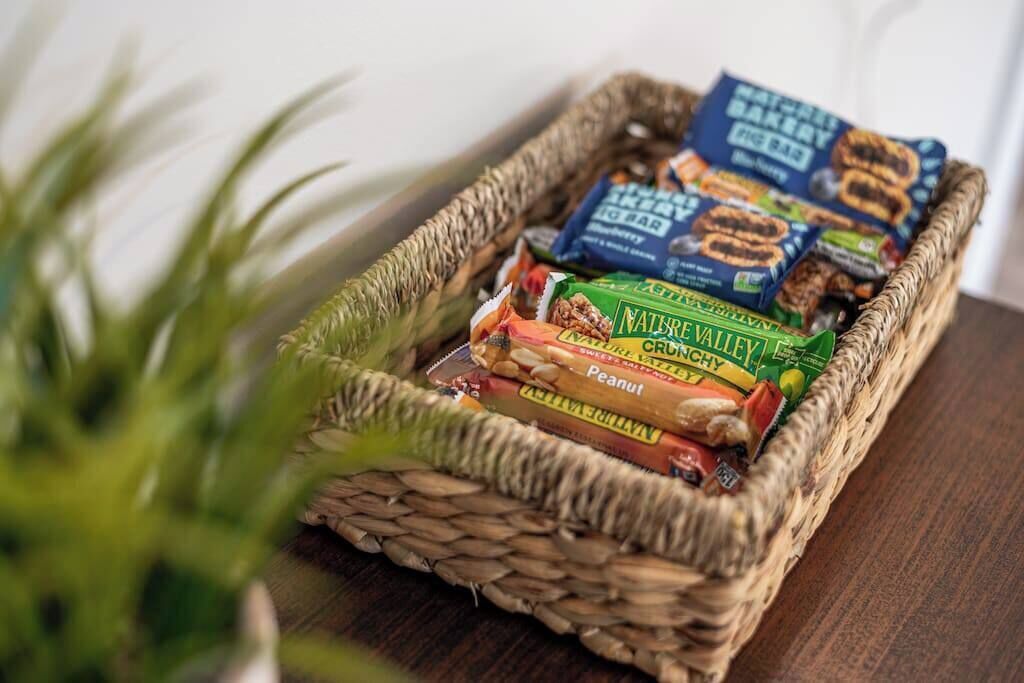 A woven basket containing snack packages on a wooden surface.