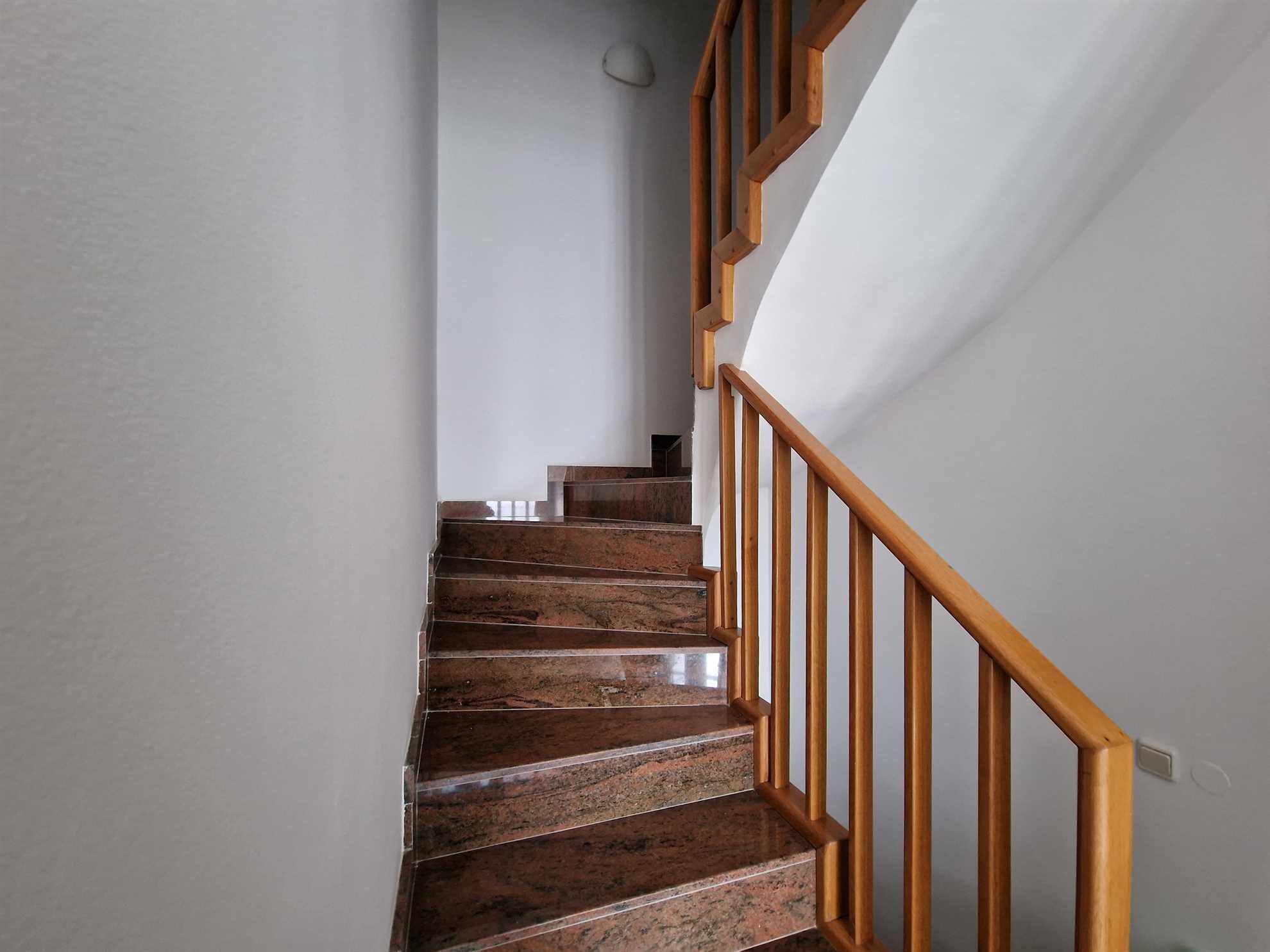 A staircase with wooden handrails and stone steps.