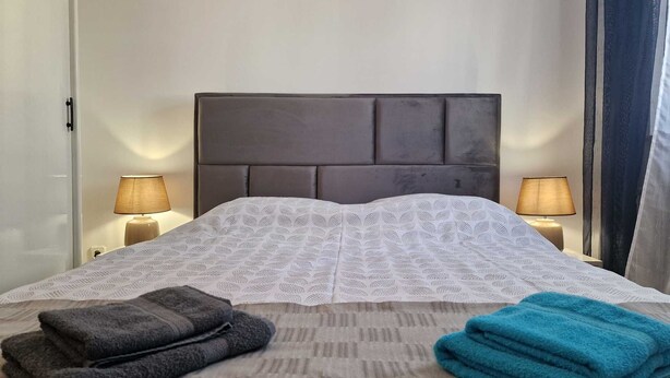 A hotel room with a bed, two bedside lamps, and two folded towels. - KATARINA B4 - Studio Apartment (Rovinj)