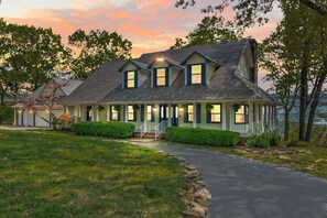 A two-story house with a covered porch and a driveway leading to the entrance. - Ultimate Lakeview w/ Private Outdoor Pool, Hot Tub, Yard, Karaoke, Billiards, Arcade & Free Tickets (Branson)