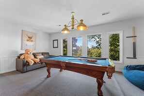 A pool table in a room with a large window, a teddy bear, and a ceiling light fixture. - Ultimate Lakeview w/ Private Outdoor Pool, Hot Tub, Yard, Karaoke, Billiards, Arcade & Free Tickets (Branson)