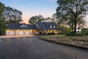 A two-story house with a garage, a covered porch, and a stone retaining wall. - Ultimate Lakeview w/ Private Outdoor Pool, Hot Tub, Yard, Karaoke, Billiards, Arcade & Free Tickets (Branson)