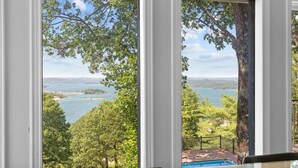 A room with a large window offering a view of a lake and trees. - Ultimate Lakeview w/ Private Outdoor Pool, Hot Tub, Yard, Karaoke, Billiards, Arcade & Free Tickets (Branson)