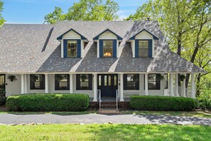 A two-story house with a gabled roof, a front porch with columns, and a symmetrical facade. - Ultimate Lakeview w/ Private Outdoor Pool, Hot Tub, Yard, Karaoke, Billiards, Arcade & Free Tickets (Branson)